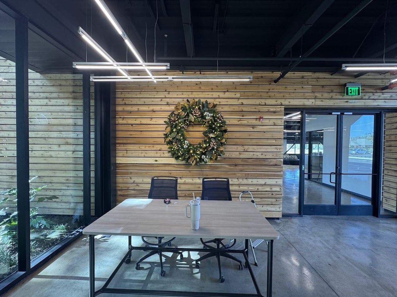 Lit magnolia-and-copper wreath on a cedar wall