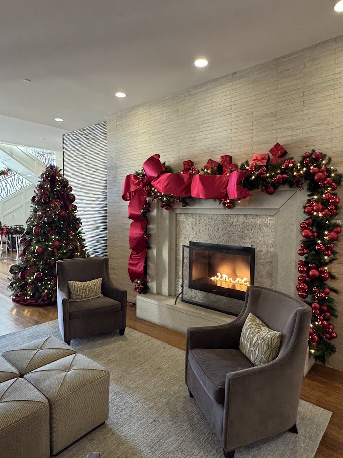 Red holiday garland and tree in a lobby seating area
