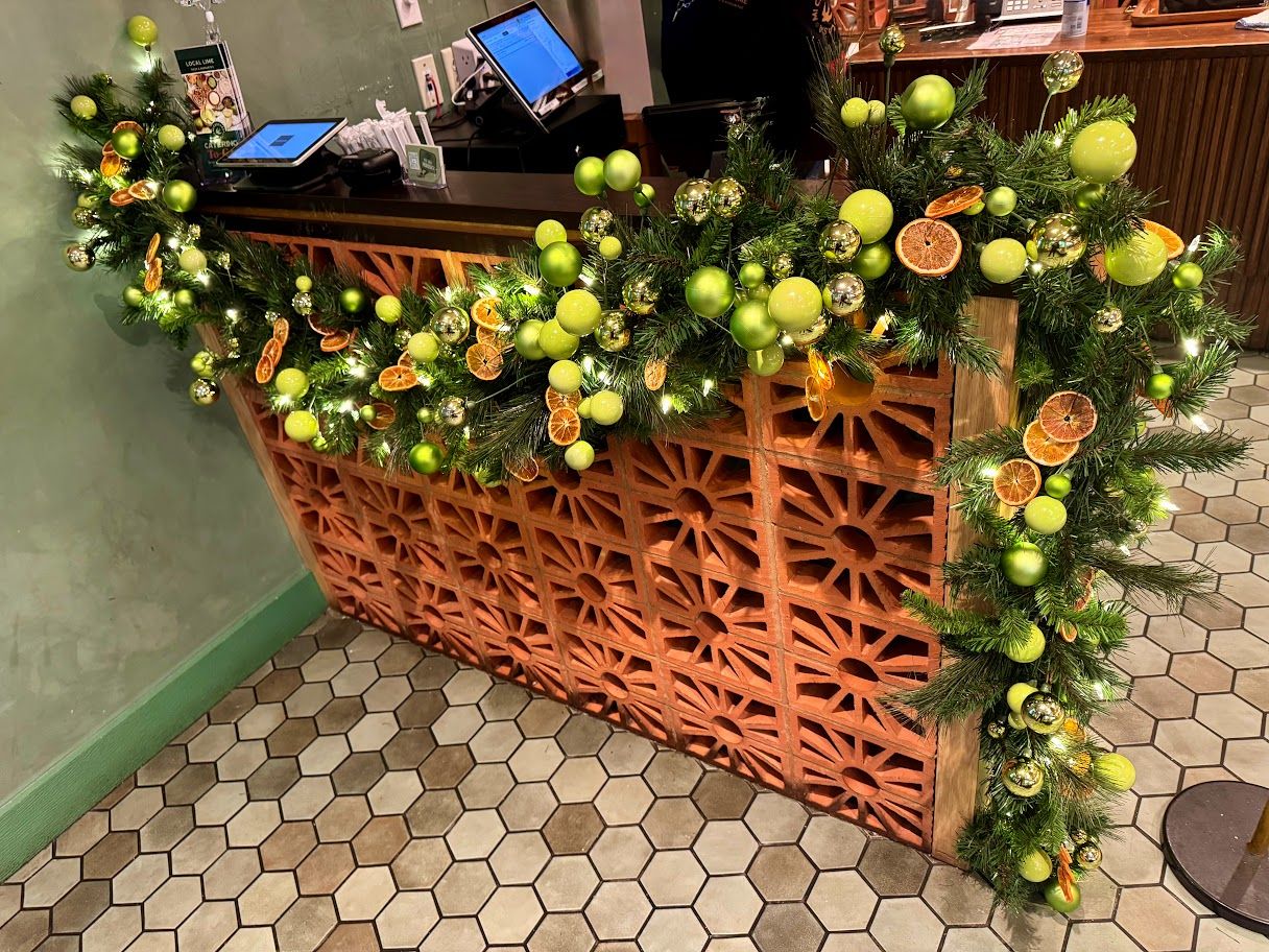 Green ornament and dried-citrus garland on a host stand