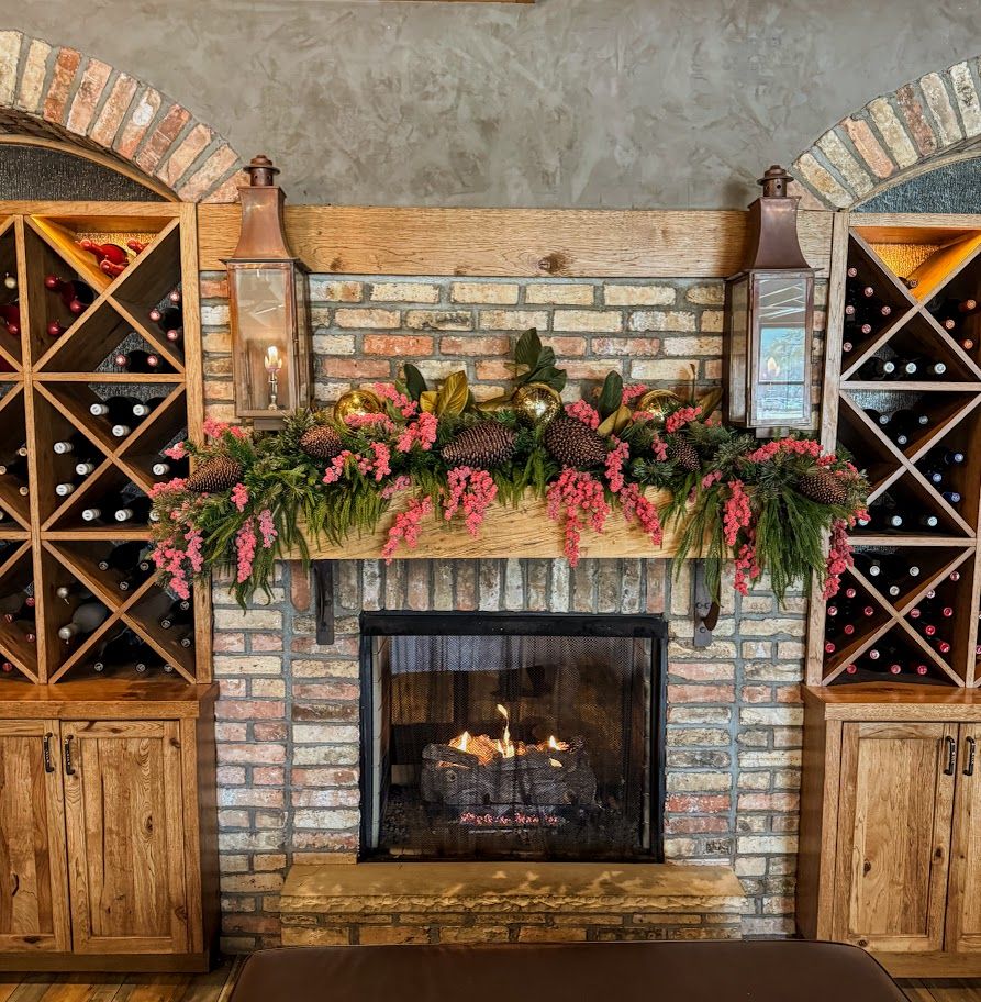 Coral berry, magnolia and pinecone mantel garland in a wine room